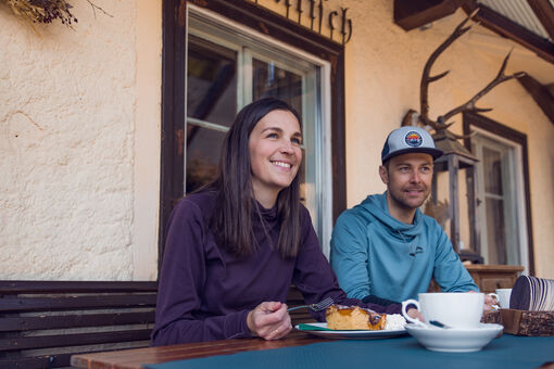 Hot drinks and delicious cakes are perfect to refuel after your winter adventure. This couple enjoys a break in the Waldhäusl in Steinberg am Rofan.