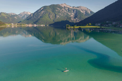 Stand Up Paddleboarding am Südufer des wunderschönen Achensees. Im Hintergrund der Seeberg und der Seekar.