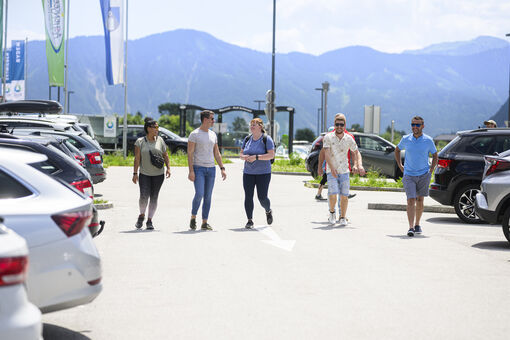 Freunde gehen beim Parkplatz des Atoll Achensee gemeinsam zum Auto.