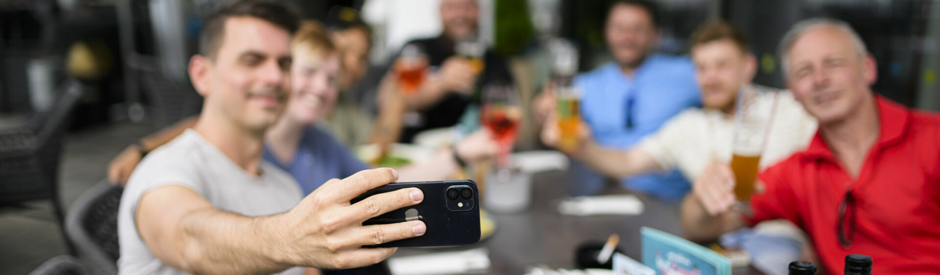 A group of friends taking a selfie at the restaurant of the Atoll Achensee.