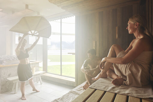 A couple is enjoying the sauna infusion in the wellness area of Atoll Achensee.